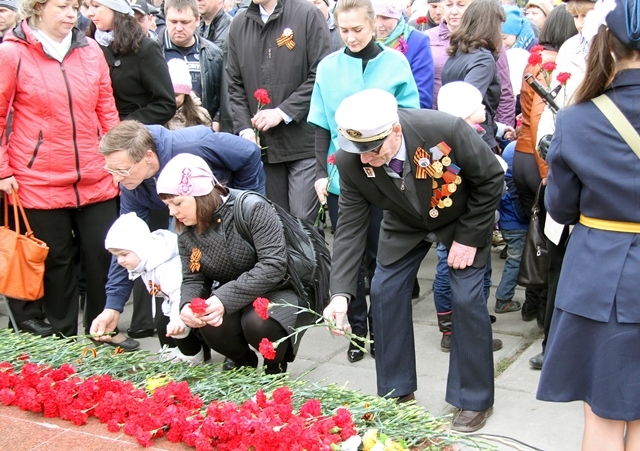 Цветы к мемориалу воинам-металлургам возлагает ветеран войны Евгений Швецов (справа)