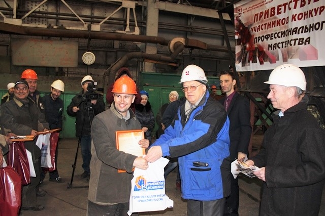 Технический инспектор труда ГМПР Павел Тилькун вручает подарок от профсоюзной организации победителю конкурса Дмитрию Кропачеву.