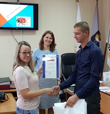 Председатель комиссии профкома по работе с молодежью Алексей Дубограй вручает награды команде "Молекулы".