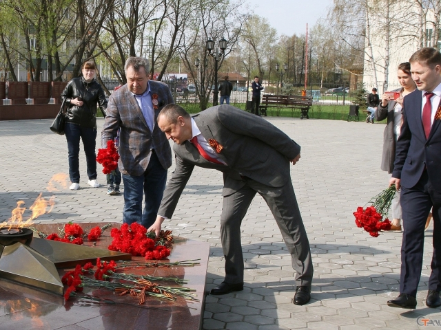 Директор завода Дмитрий Штин возлагает цветы к Вечному огню мемориала воинам-металлургам.